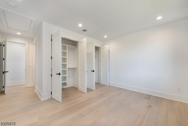 unfurnished bedroom featuring light hardwood / wood-style flooring and a closet