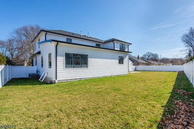 rear view of house with a yard and central air condition unit