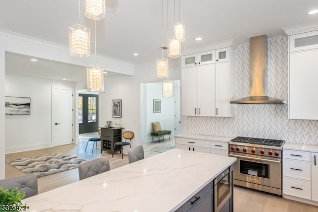 kitchen with white cabinetry, pendant lighting, wall chimney exhaust hood, and appliances with stainless steel finishes