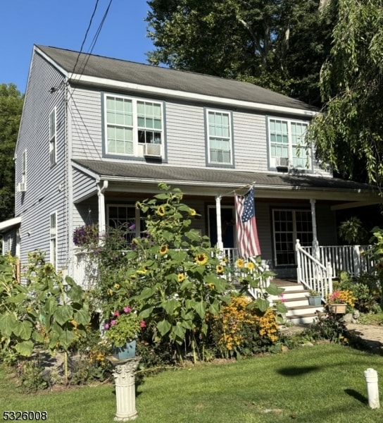 view of front of home featuring covered porch and a front yard