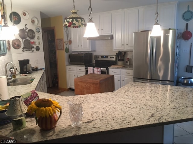 kitchen featuring hanging light fixtures, sink, decorative backsplash, appliances with stainless steel finishes, and white cabinetry