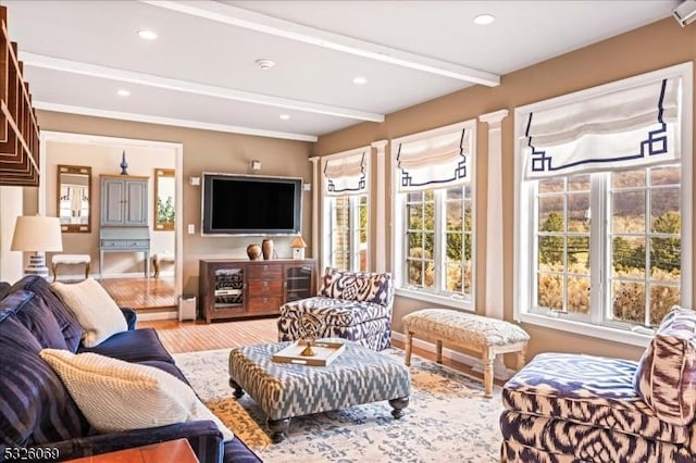 living room featuring beamed ceiling and light hardwood / wood-style floors