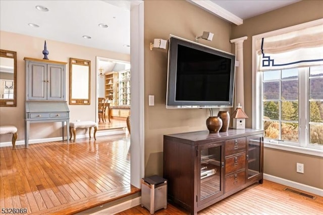 entryway with decorative columns and light hardwood / wood-style floors