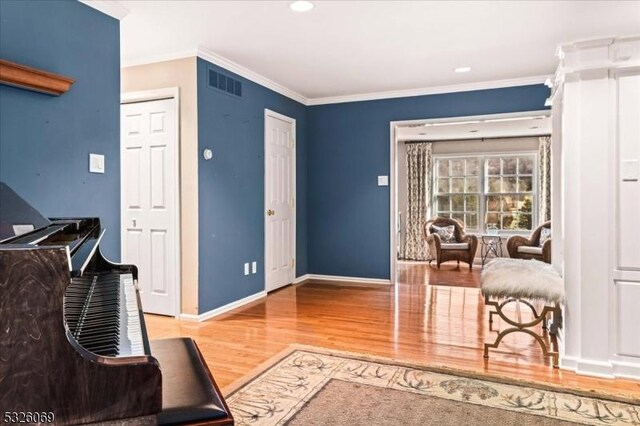 sitting room featuring wood-type flooring and ornamental molding