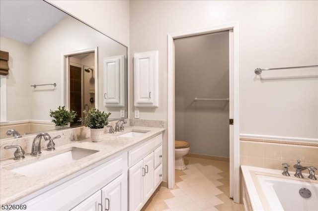 bathroom featuring vanity, tile patterned floors, vaulted ceiling, toilet, and tiled tub