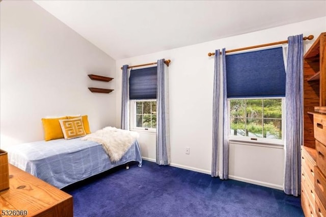 carpeted bedroom featuring vaulted ceiling and multiple windows