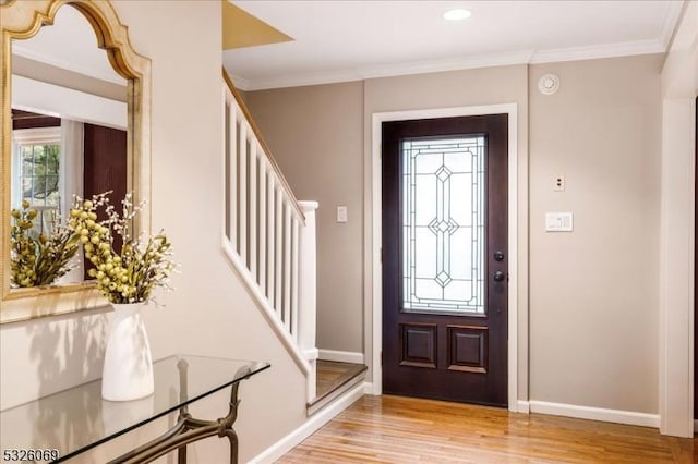 entryway with light wood-type flooring and crown molding