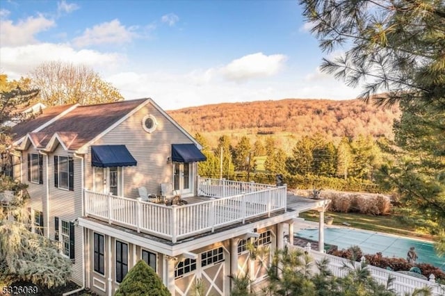 rear view of property with a balcony and a garage