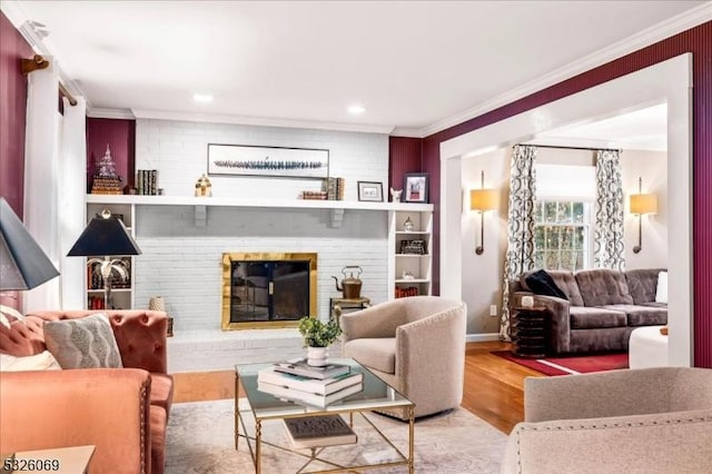 living room featuring crown molding, wood-type flooring, and a fireplace