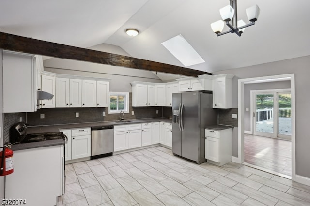 kitchen with white cabinetry, lofted ceiling with skylight, stainless steel appliances, and tasteful backsplash