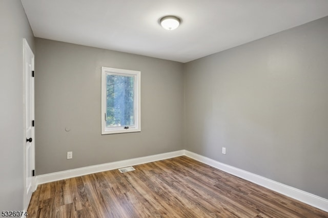 empty room with hardwood / wood-style flooring