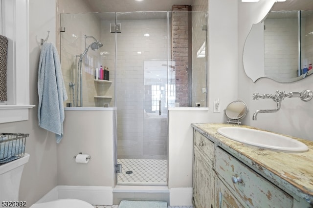 bathroom with vanity, toilet, and a shower with door