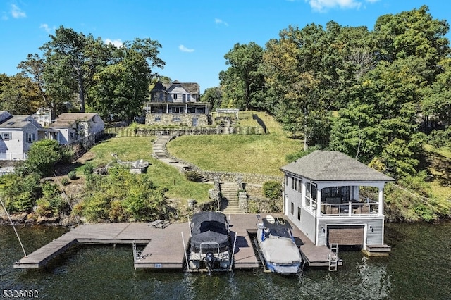 view of dock with a yard and a water view