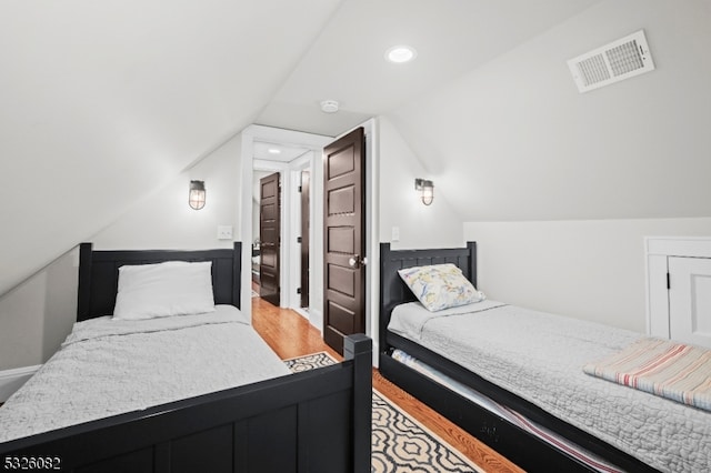 bedroom with wood-type flooring and lofted ceiling