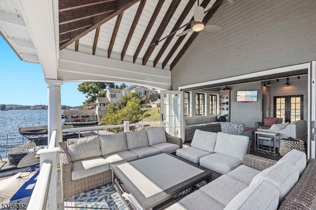 view of patio with ceiling fan, a water view, and a balcony