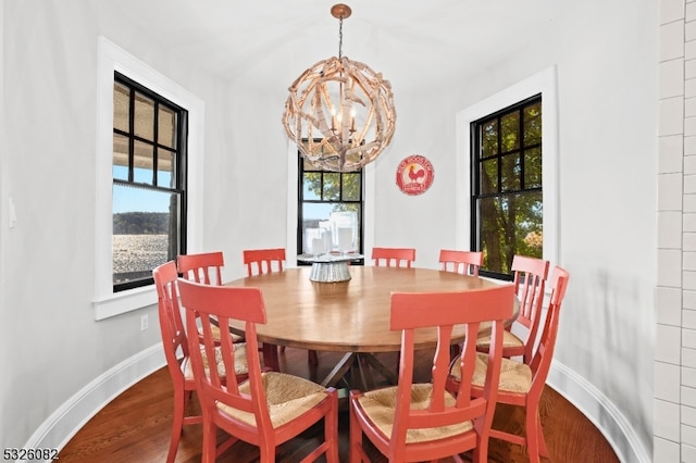 dining space featuring plenty of natural light, wood-type flooring, and an inviting chandelier