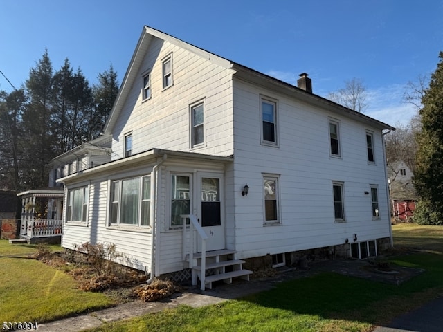 back of house featuring a lawn