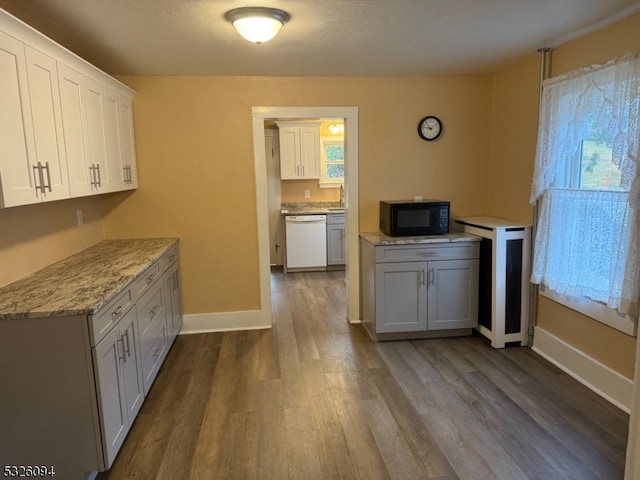 kitchen featuring white cabinets, dishwasher, light stone countertops, and dark wood-type flooring