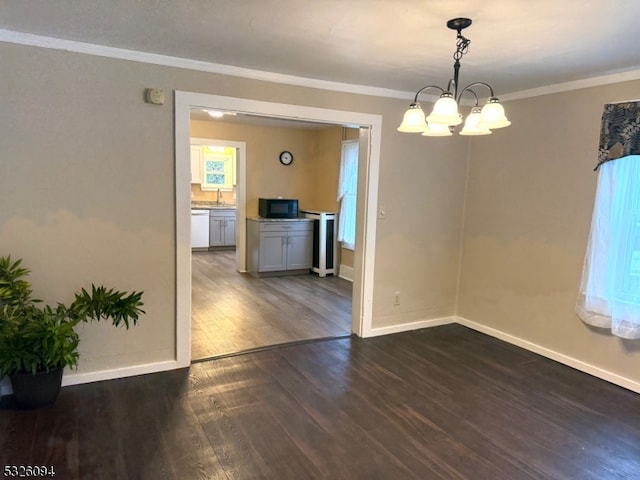 empty room featuring an inviting chandelier, a wealth of natural light, dark wood-type flooring, and crown molding