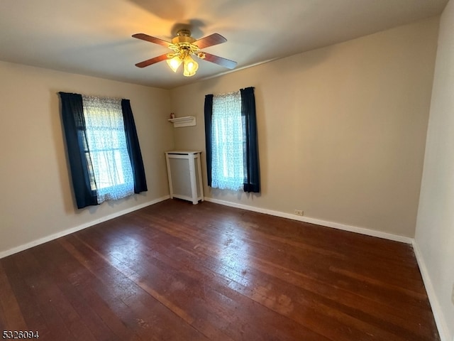 spare room with ceiling fan and dark wood-type flooring