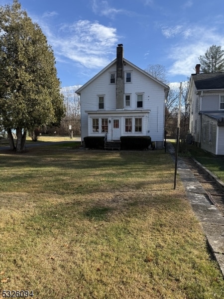 back of property featuring a lawn