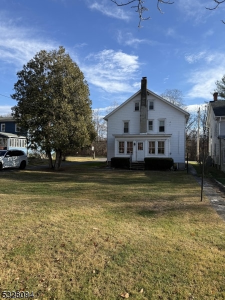 back of property featuring a yard