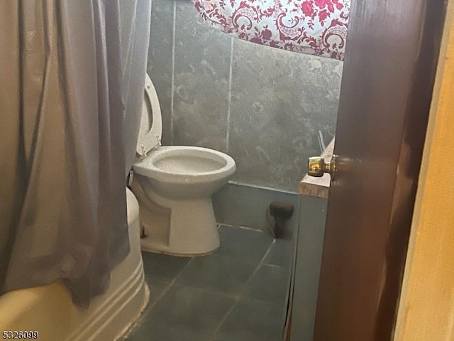 bathroom with tile patterned floors, toilet, and shower / bath combo