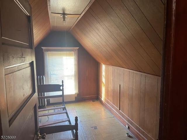 additional living space with wooden walls, lofted ceiling, and wood ceiling