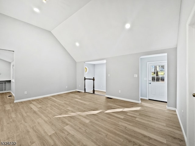 unfurnished living room with light wood-type flooring and lofted ceiling