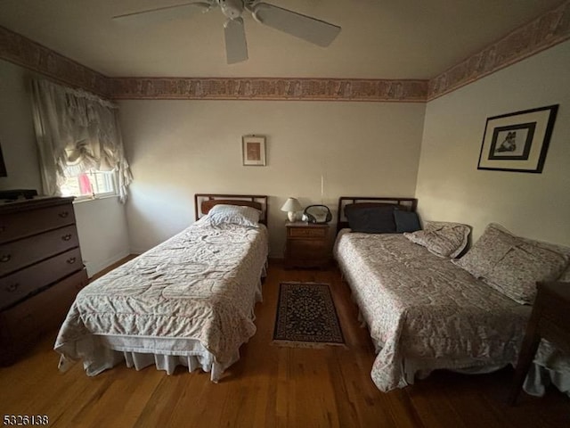 bedroom with wood-type flooring and ceiling fan