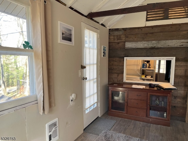 entryway with hardwood / wood-style floors, lofted ceiling with beams, heating unit, and plenty of natural light