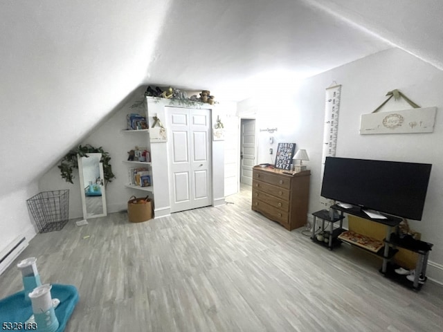 additional living space featuring hardwood / wood-style flooring, baseboard heating, and lofted ceiling