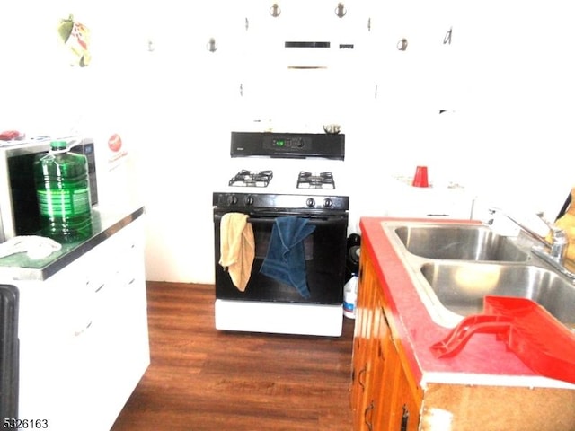 kitchen featuring black range with electric stovetop, white cabinetry, sink, and dark hardwood / wood-style floors