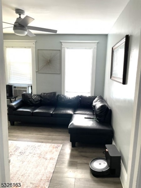 living room featuring ceiling fan, hardwood / wood-style floors, and cooling unit