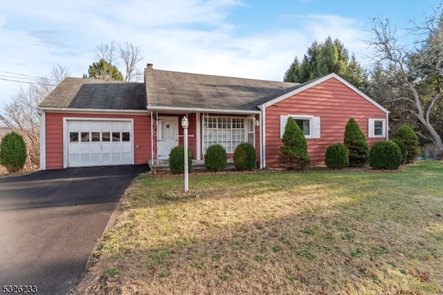 ranch-style home featuring a garage and a front lawn