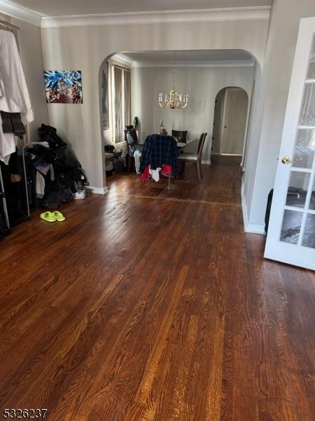 dining room with dark hardwood / wood-style flooring, ornamental molding, and an inviting chandelier