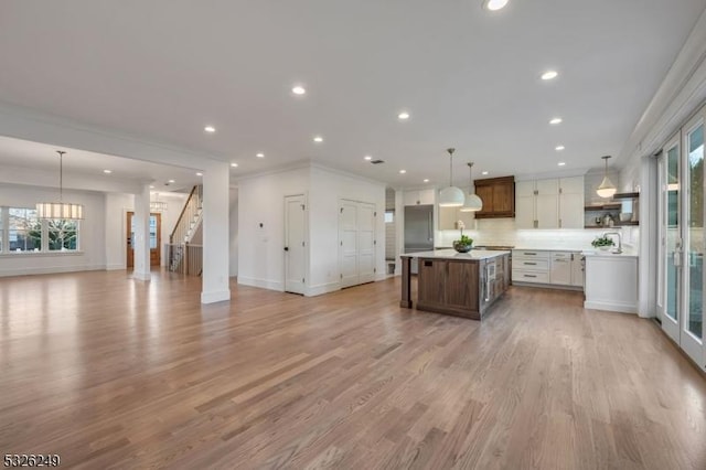 kitchen featuring a center island, decorative light fixtures, white cabinetry, and a healthy amount of sunlight