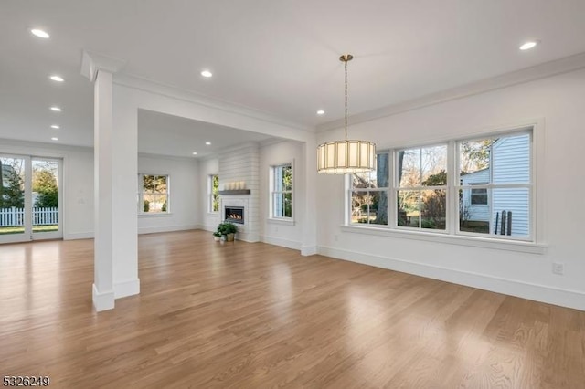 unfurnished living room with a fireplace, plenty of natural light, and light hardwood / wood-style flooring