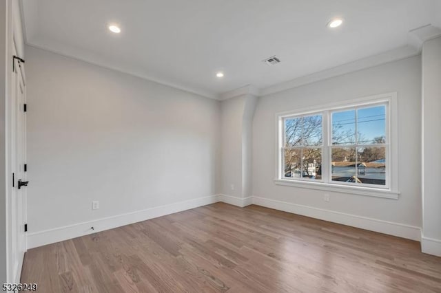 empty room with hardwood / wood-style floors and ornamental molding