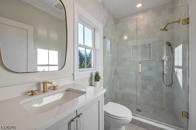 bathroom featuring vanity, toilet, and an enclosed shower