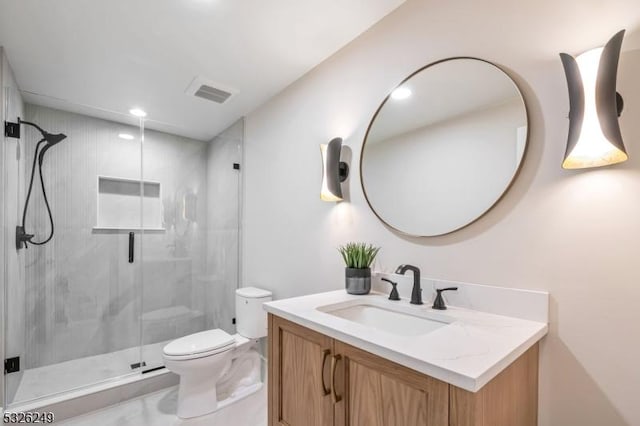 bathroom with vanity, toilet, and a shower with door