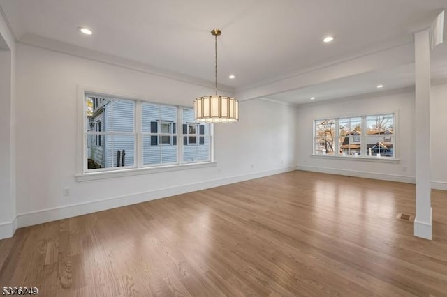 unfurnished dining area featuring light wood-type flooring and crown molding