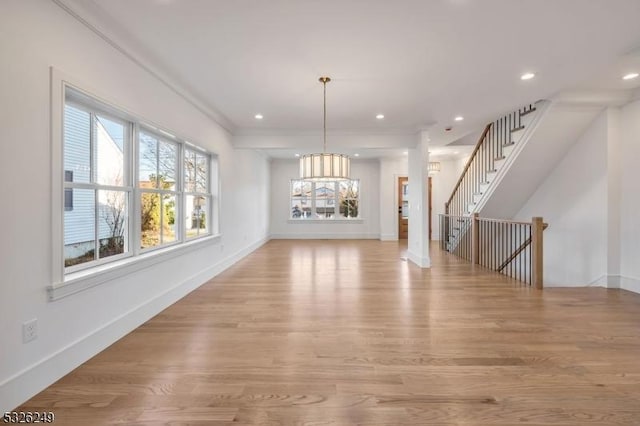 interior space featuring crown molding, an inviting chandelier, and light wood-type flooring