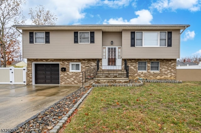 raised ranch with a front lawn and a garage