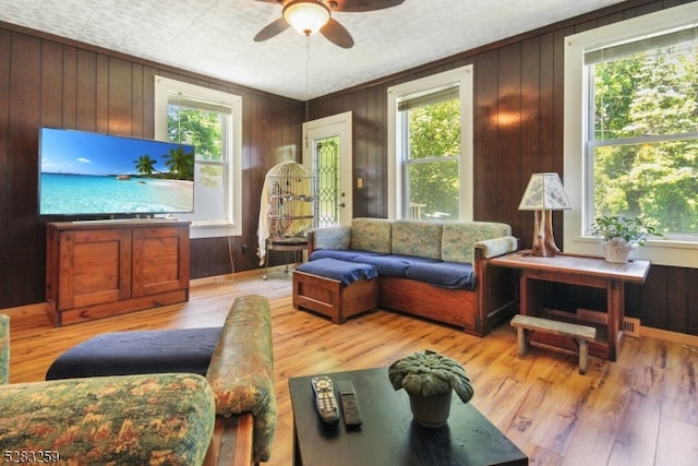 living room featuring hardwood / wood-style floors, a wealth of natural light, and wooden walls