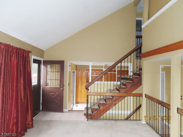 interior space with carpet floors and high vaulted ceiling