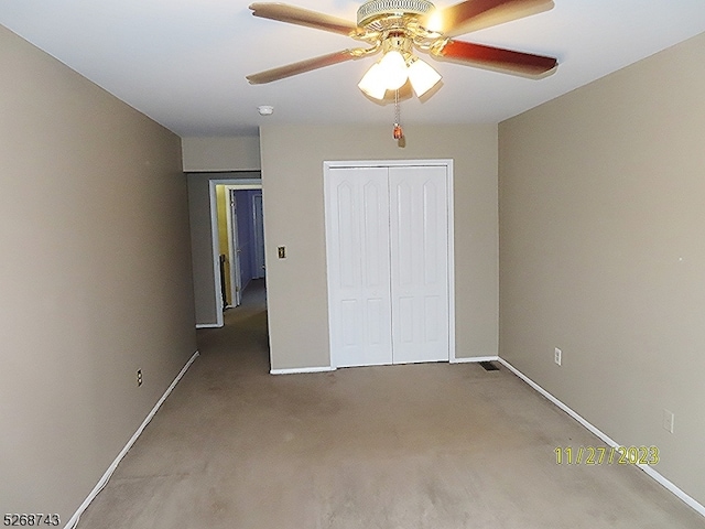 unfurnished bedroom featuring carpet, ceiling fan, and a closet