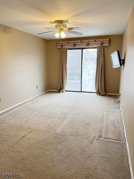 unfurnished room with light colored carpet and ceiling fan