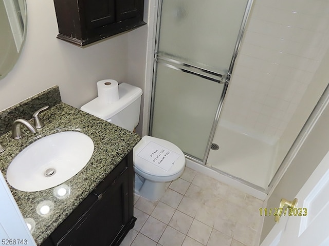 bathroom featuring tile patterned floors, vanity, toilet, and walk in shower