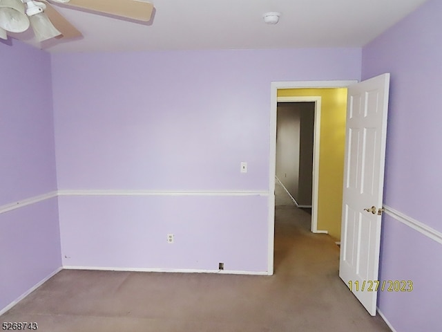 carpeted spare room featuring ceiling fan